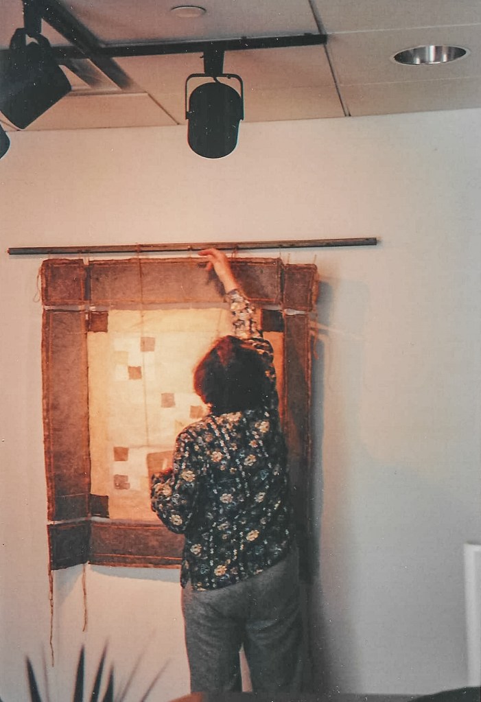 Alt text: Marcia installing a paper quilt