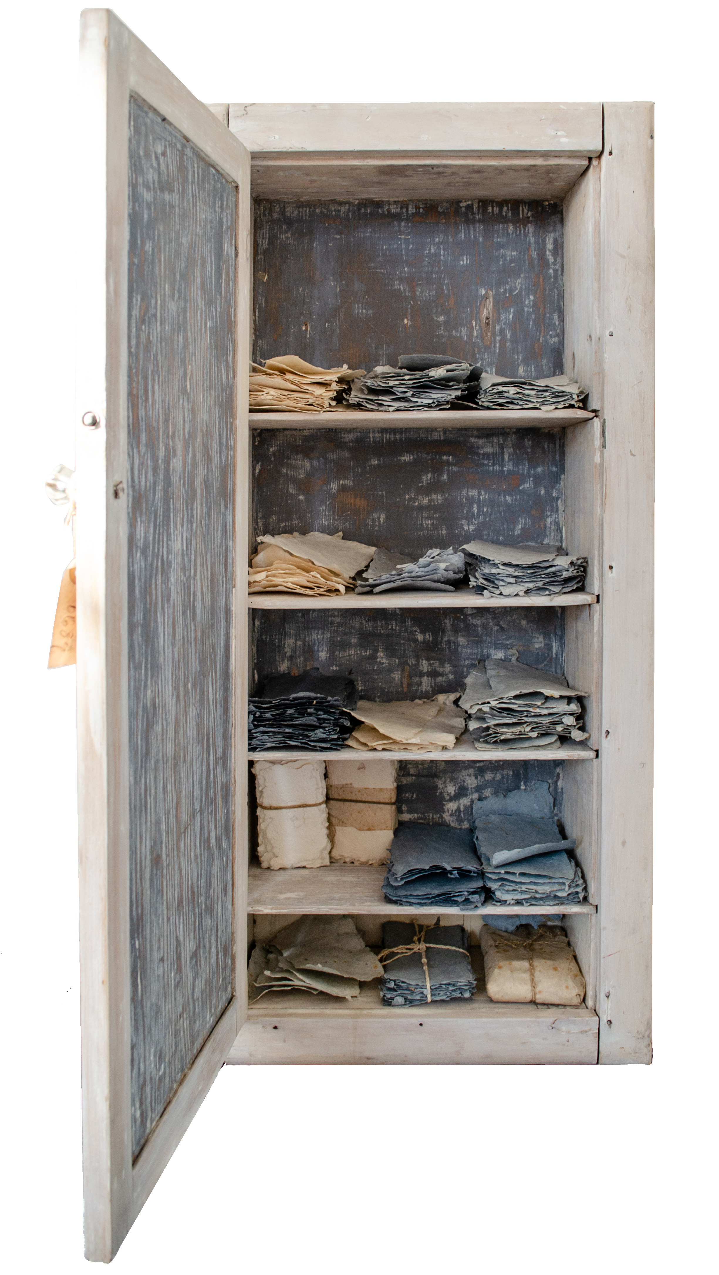 Alt text: Cupboard with scraps of handmade paper